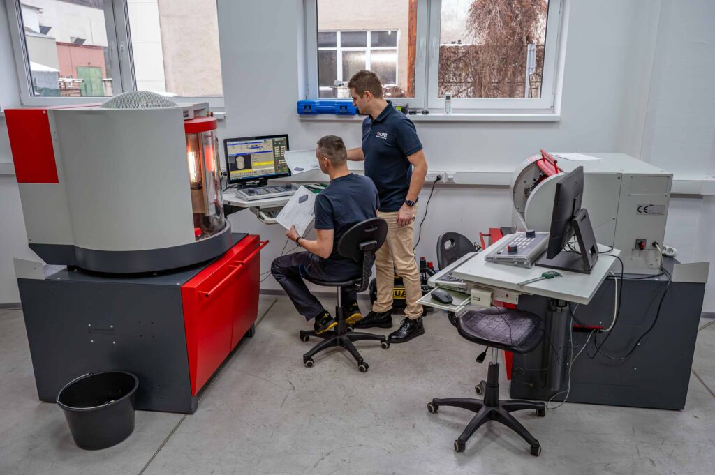 Lektor so študentom pri programovaní CNC frézy EMCO Concept Mill 55, v pozadí CNC sústruh EMCO Concept Turn 60