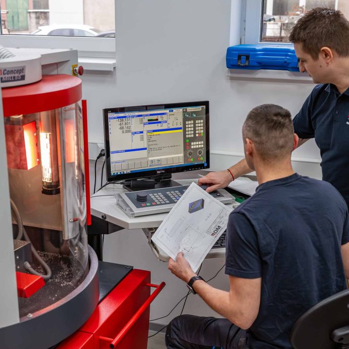 Výučba práce s CNC frézou na kurze Akadémie CNC Dvaja účastníci kurzu ovládajú CNC frézu pomocou riadiaceho softvéru v priestoroch RD Mold Machining