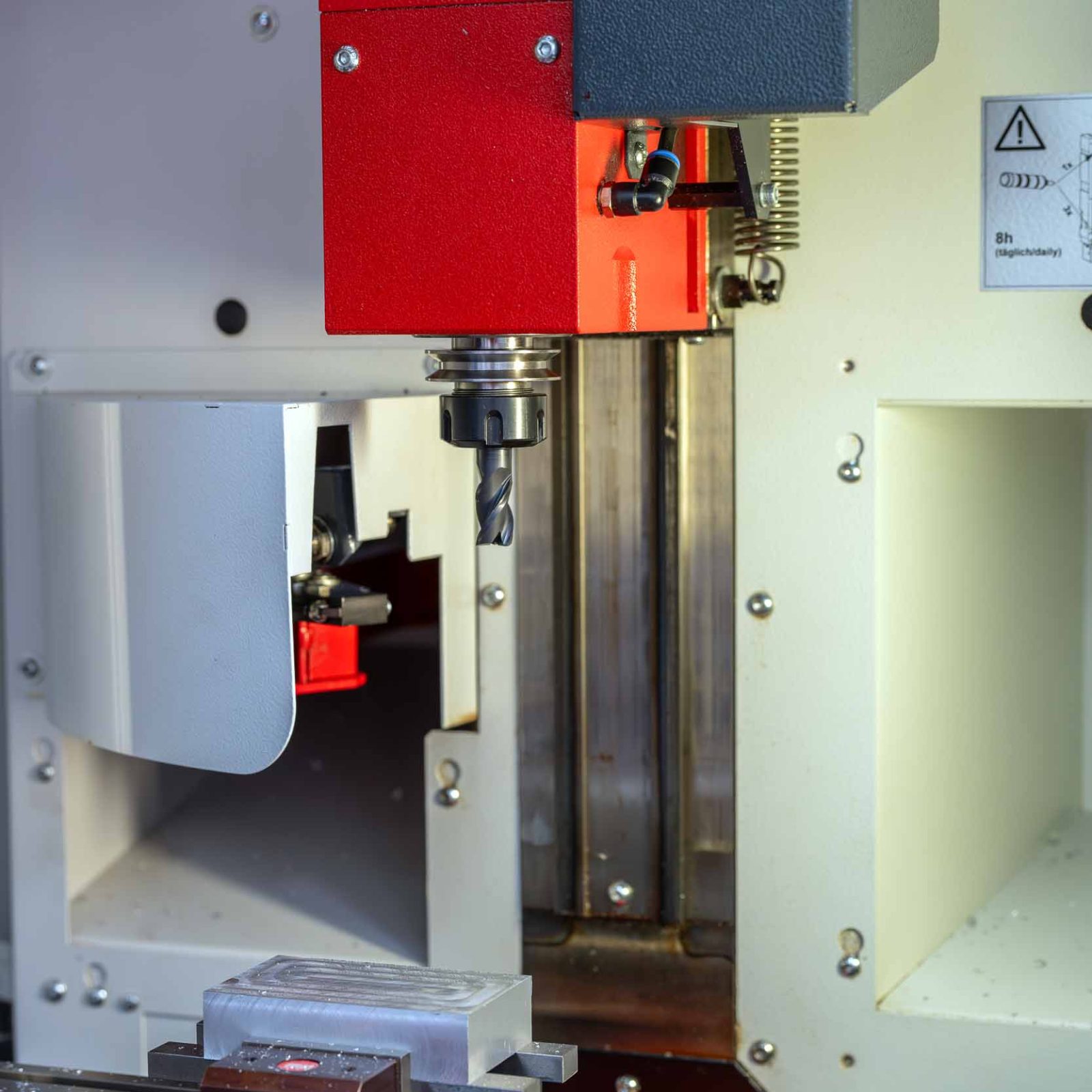 Presnosť v každom detaile Detail frézovacieho nástroja a upnutého obrobku v CNC fréze počas kurzu Akadémie CNC