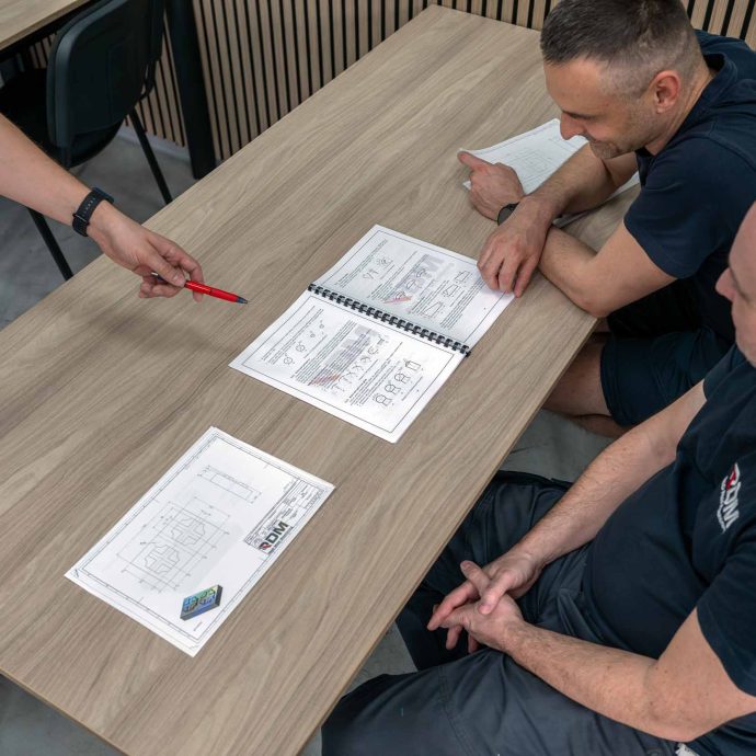 Individuálny prístup vďaka malej skupine Traja účastníci kurzu Akadémie CNC konzultujú technické výkresy s lektorom v učebni RD Mold Machining